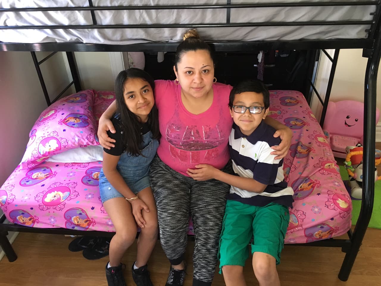 Los niños Arleth y José abrazan a su madre, Vanessa Pineda, en su hogar en Pico-Union, California.