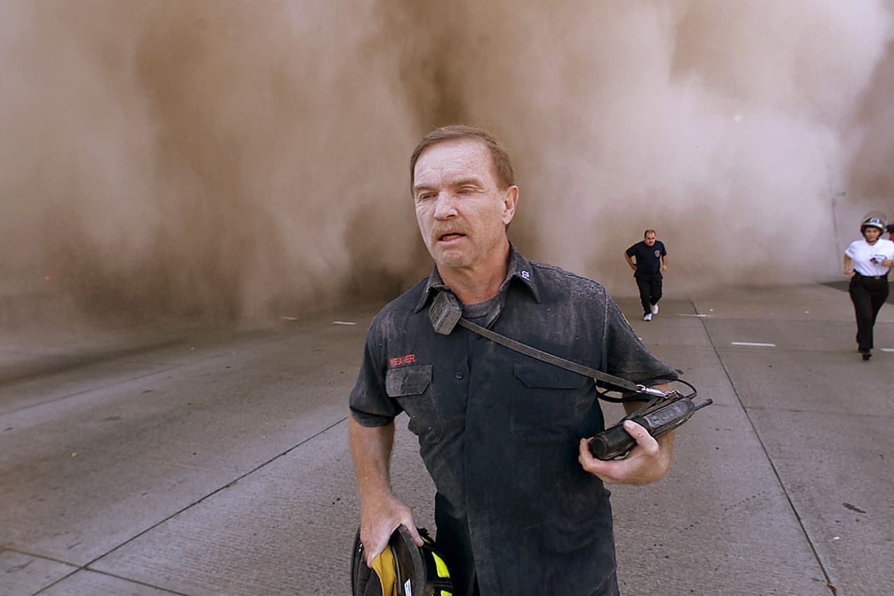 Un bombero se aleja a toda velocidad de la nube de escombros generada por el primer colpaso. La Torre Sur cayó a las 9:59 AM, menos de una hora después de haber sido impactada por el vuelo 93 de United Airlines.