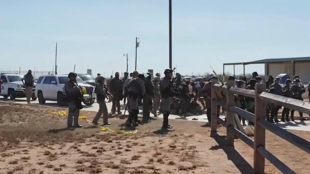 Oficiales y manifestantes se enfrentan afuera del centro de detención en Dilley, Texas