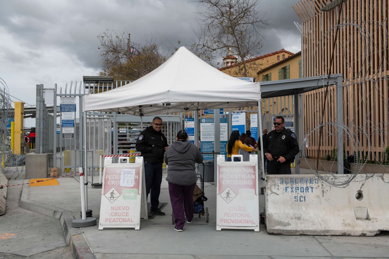Oficiales con La Oficina de Aduanas y Protección Fronteriza de los Estados Unidos (CBP) dirigen a los que intentan cruzar a los Estados Unidos.