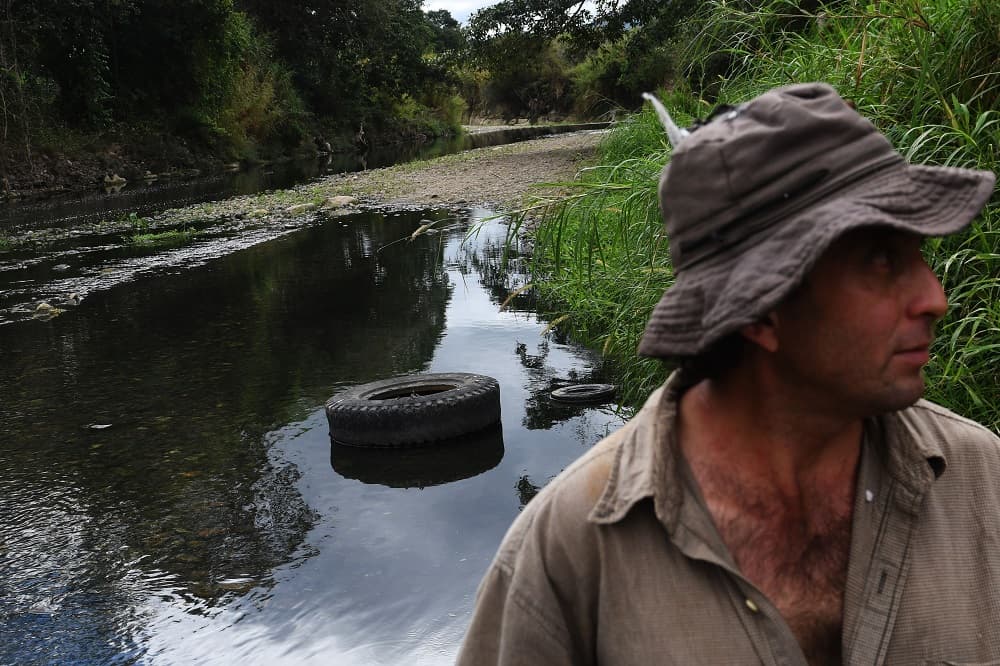 Con el fin de detener la contaminación, en diciembre pasado la Mancomunidad se reunió infructuosamente con los cafetaleros guatemaltecos de Esquipulas. En la imagen, un hombre junto a las aguas contaminadas del río.