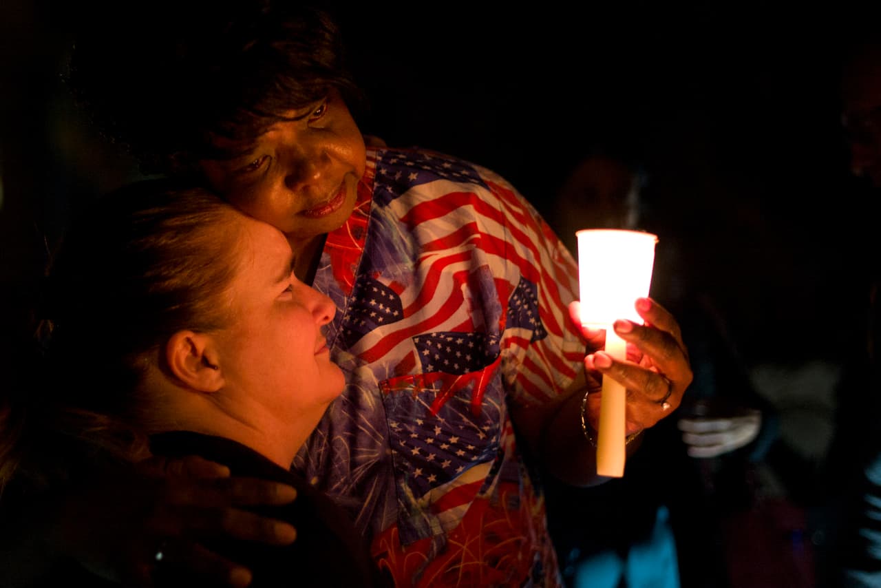 <b>2015. Salón de fiestas en</b> 
<b>San Bernardino, California. </b>Un evento social del Departamento de Salud Pública del condado fue interrumpido por las balas de las armas de asalto disparadas por los esposos 
<a href="https://www.univision.com/los-angeles/kmex/noticias/tiroteo-en-san-bernardino/los-interrogantes-que-siguen-abiertos-un-ano-despues-del-ataque-terrorista-en-san-bernardino">Tashfeen Malik y Syed Rizwan Farook, quienes asesinaron a 14 personas</a>. Farook era estadounidense de ascendencia pakistaní y trabajaba con las víctimas en el departamento de salud. Malik, su esposa, nació en Pakistán y era residente legal en EEUU. La pareja murió al enfrentarse con la policía. En la fotografía Lisa Hamons y Yolanda Richardson, trabajadoras del condado de San Bernardino, en una vigilia por las víctimas de la tragedia. 7 de diciembre de 2015.