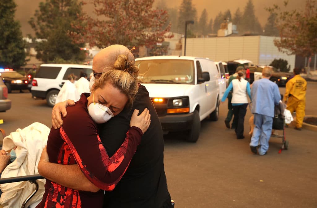 Una trabajadora del Hospital Feather River abraza a su compañero de trabajo mientras se evacuan a los pacientes durante el Camp Fire en Paradise. Justin Sullivan/Getty Images