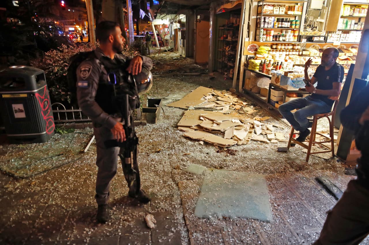 Un policía israelí habla con el dueño de un local dañado por el impacto de los cohetes en Holon, cerca de Tel Aviv. El ministro de Defensa israelí, Benny Gantz, que fue jefe del ejército durante el último conflicto en Gaza en 2014, advirtió a Hamas que "todavía hay muchos objetivos en la mira. Esto es solo el comienzo".