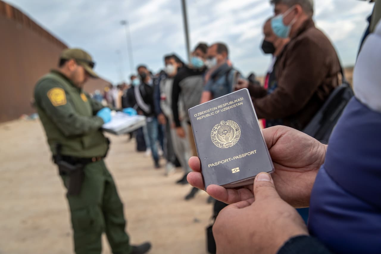 Un inmigrante de Uzbekistán espera junto a otros de diferentes países para ser detenido por agentes de la Patrulla Fronteriza en Yuma, Arizona. Según la agencia migratoria por ese sector han estado procesando migrantes de 30 nacionalidades. Los inmigrantes cruzan con sus familias a través de una brecha cercana en el muro fronterizo para buscar asilo político en Estados Unidos. En muchos casos, las mujeres y los niños fueron transportados primero a las instalaciones de procesamiento.