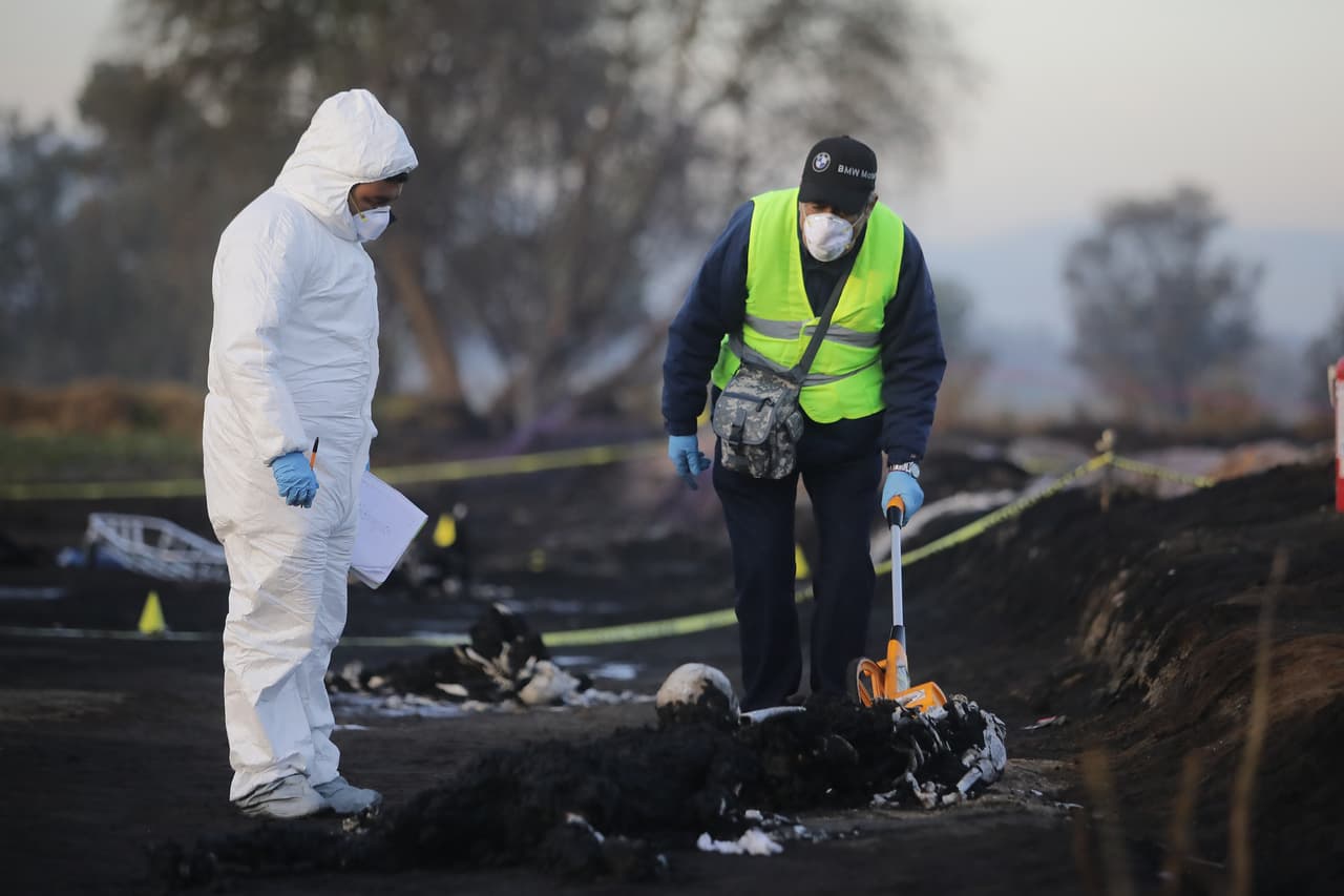 Forenses recuperan restos calcinados tras la explosión de un ducto de combustible en Tlahuelilpan, México.