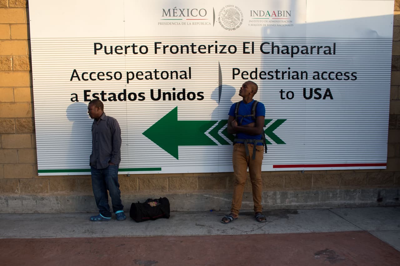 Migrantes haitianos que buscan asilo en Estados Unidos esperan en el cruce fronterizo de El Chaparral, Tijuana, con la esperanza de obtener una cita con las autoridades migratorias estadounidenses. 7 de octubre 2010.