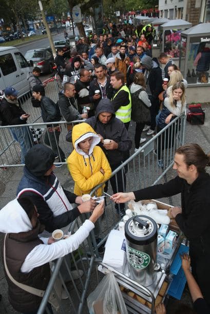La gente en Berlin compraba cafe mientras esperaba entrar a la tienda de Apple.