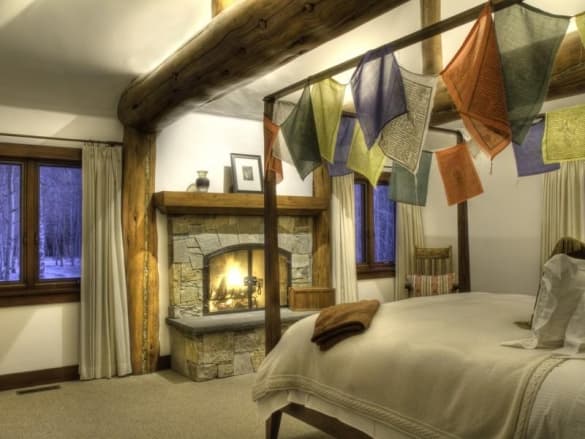 En el interior, la sala tiene pilares de madera, repisas-libreros y una chimenea de piedra detrás de la cual se ofrece una vista preciosa de los árboles circundantes.