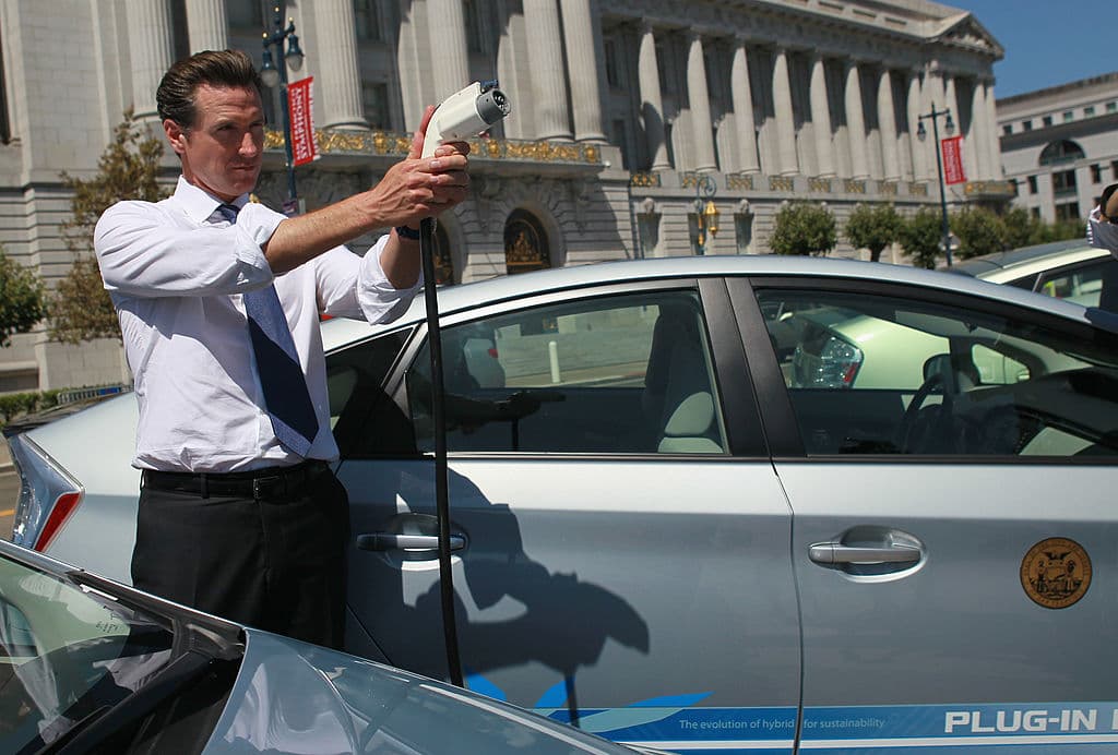 El ahora gobernador de California Gavin Newsom, sostiene un cable de alimentación antes de probar una versión enchufable de un automovil híbrido y eléctrico Toyota Prius que fue uno de los cuatro prestados a la ciudad para su evaluación, el 25 de agosto de 2010 en San Francisco, California.
<br>