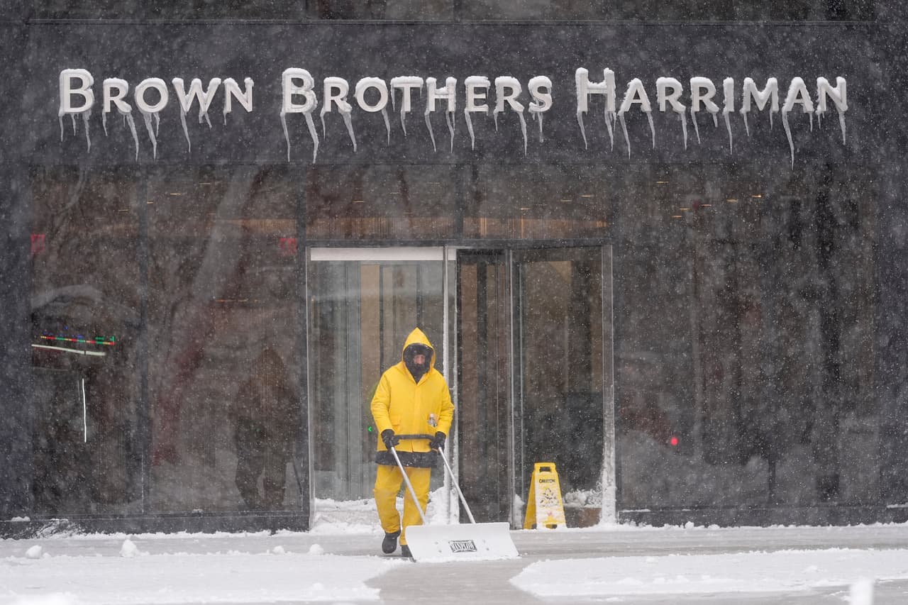 Un hombre limpia la nieve de una acera en el bajo Manhattan durante una tormenta de nieve.