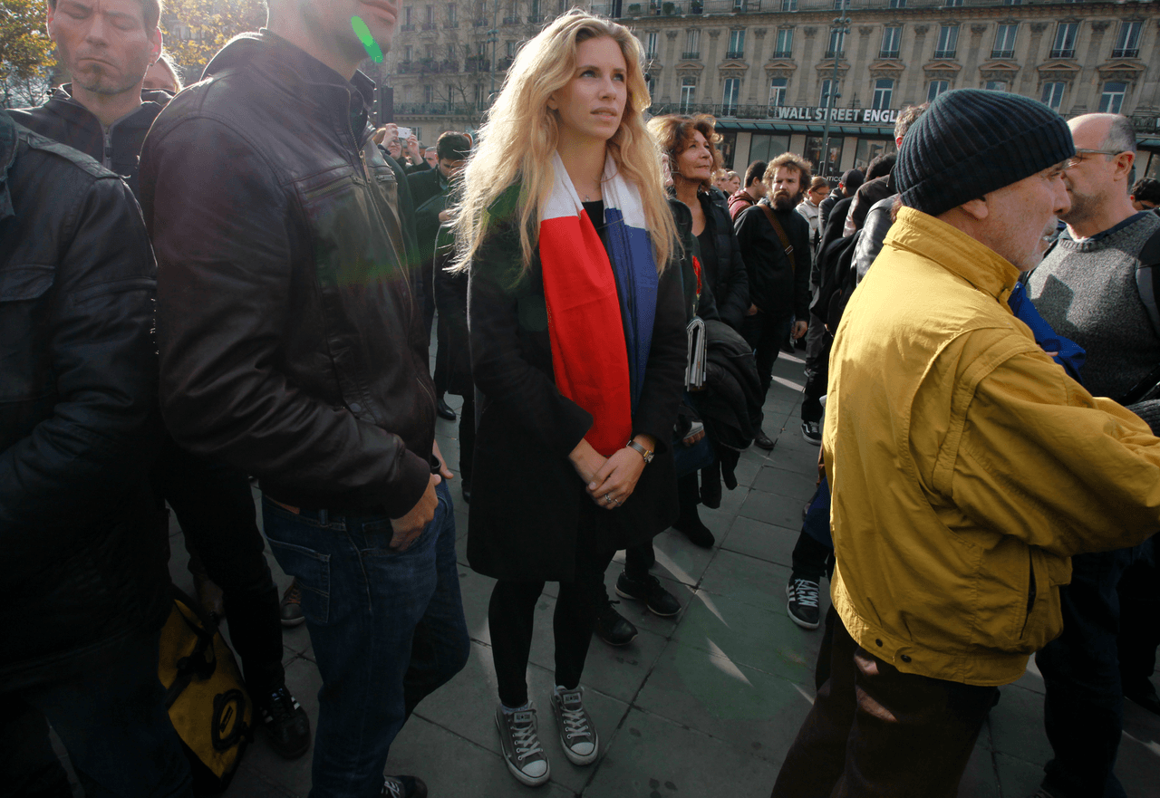 Una mujer porta una bandera de Francia en las calles de París
