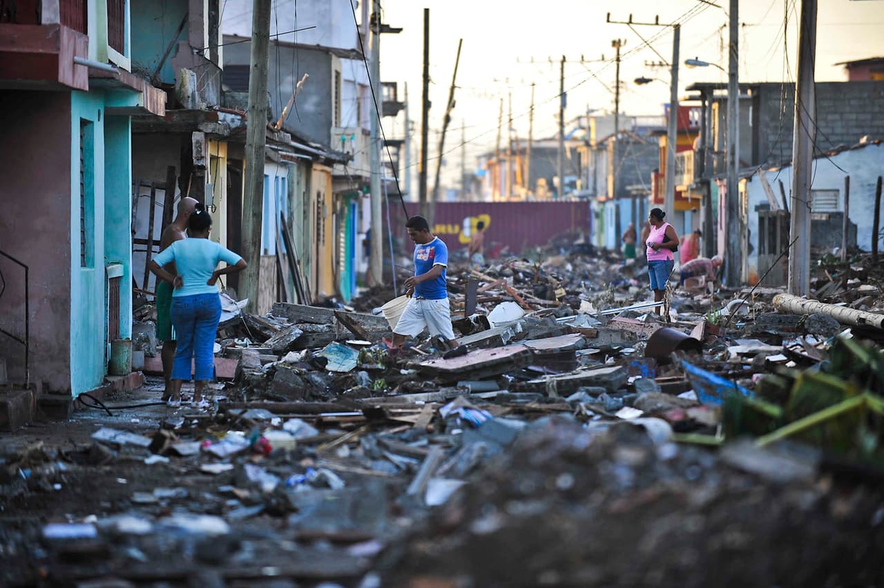 Los habitantes de la ciudad del oriente cubano, Baracoa, caminan por las calles llenas de escombros.