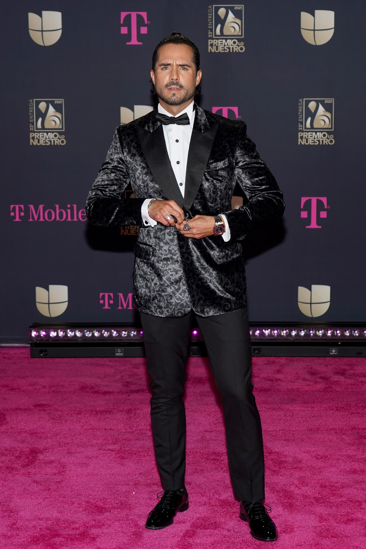 Jos´´e Ron también destacó con su saco aterciopelado y su corbata de moño. Recogió su melena en un chongo samurai.