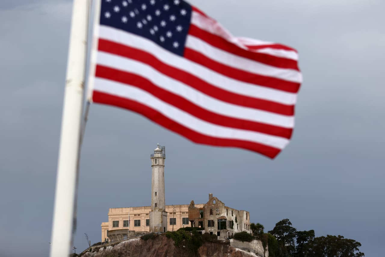 Una bandera estadounidense
<b> </b>enmarca en la distancia a la isla de Alcatraz el día de su reapertura,
<b>después de cinco meses de cierre provocado por la pandemia del coronavirus. </b>