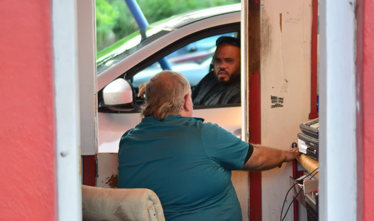 El cajero vende los tiquetes a las personas sin que se bajen de su carro.
<br>