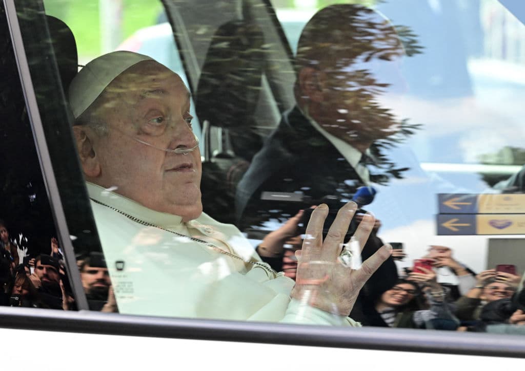 El papa Francisco saluda desde el auto en que fue trasladado este domingo tras ser dado de alta del hospital Gemelli.