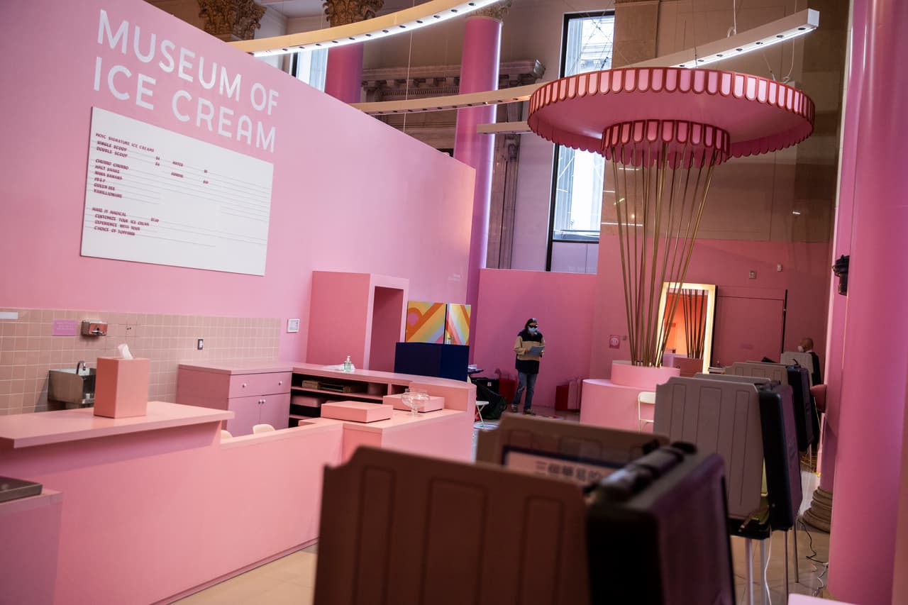 A lo lejos, una votante entra al "Museo del Helado" de San Francisco, donde se habilitó otro centro de votación. Si no sabes cómo encontrar el que te corresponde, la dirección viene impresa en la última página de la guía para el votante que recibiste por correo de la Oficina de Elecciones de tu condado.