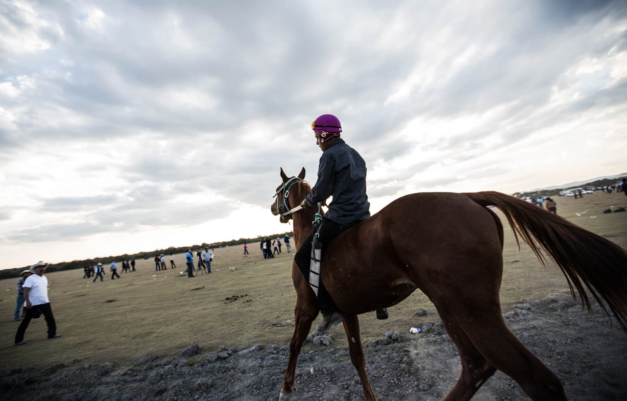 Un jinete galopa despacio después de que la carrera de caballos se suspendiera tras la primera carrera de dos jinetes. Uno de ellos resultó muerto y otra persona herida, pero la información, en un evento sin cobertura de celular ni internet, no se extendió de manera uniforme ni regular. Algunos participantes del evento no sabían de lo sucedido la mañana siguiente. Almudena Toral