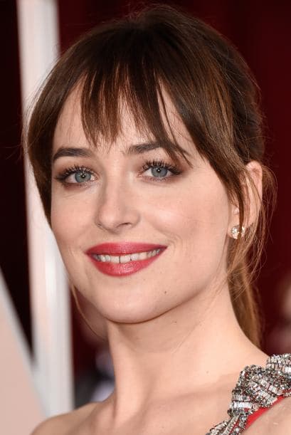 Dakota Johnson eligió 'ponytail' y flequillo relajados para darle frescura al 'look' al portar el sexy modelo de Saint Laurent de un solo hombro.