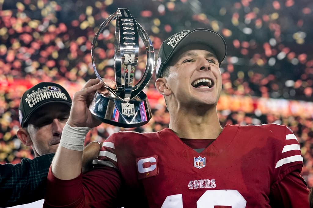 El mariscal de campo de los 49ers de San Francisco, Brock Purdy, celebra con el trofeo después de su victoria contra los Lions de Detroit en el partido de fútbol americano de la NFL por el campeonato de la NFC en Santa Clara, California, el domingo 28 de enero de 2024. (Foto AP/Godofredo A. Vasquez)