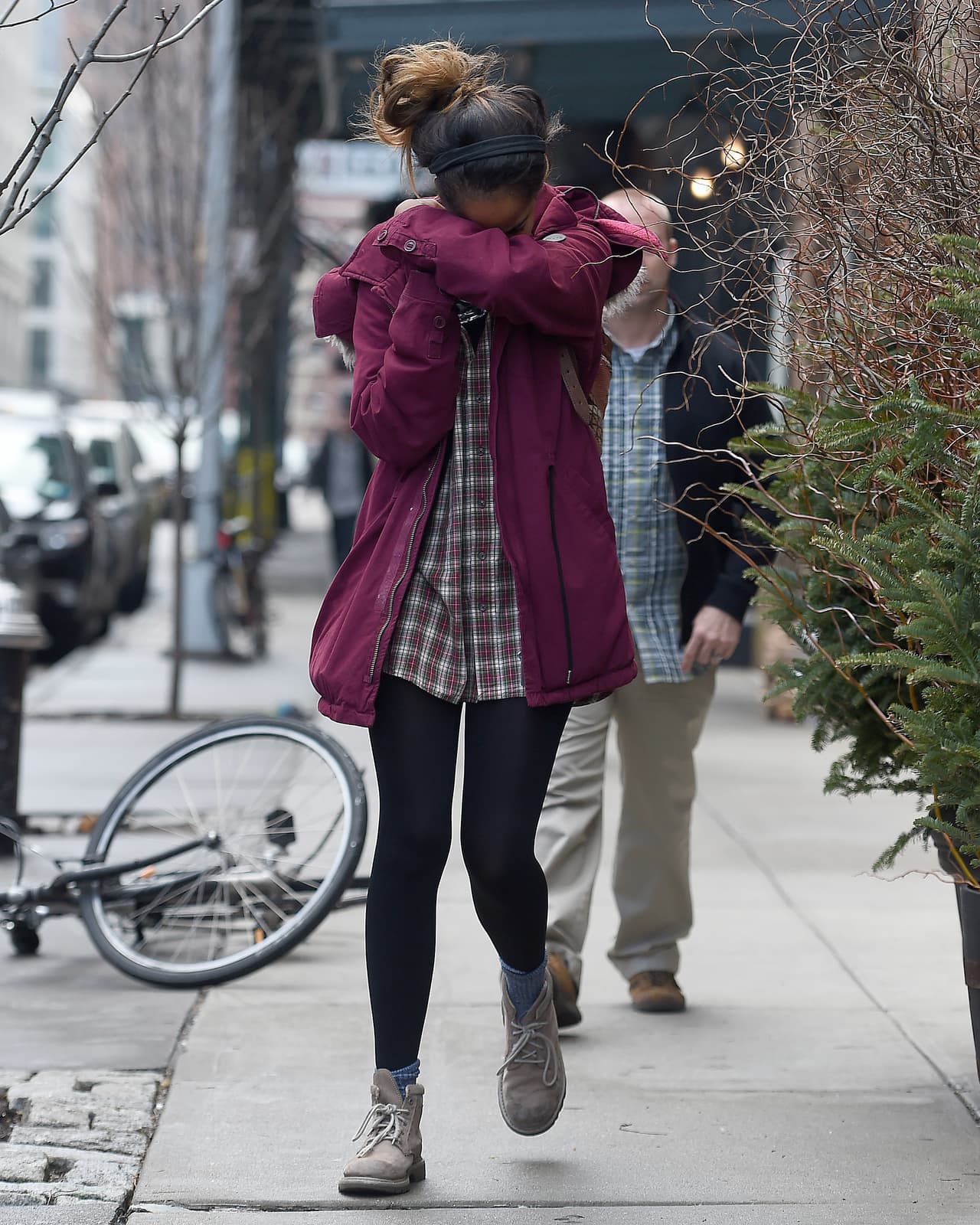 Malia Obama, un poco cansada de los paparazzis, luce un abrigo marrón, camisa a cuadros y su pelo cogido.
