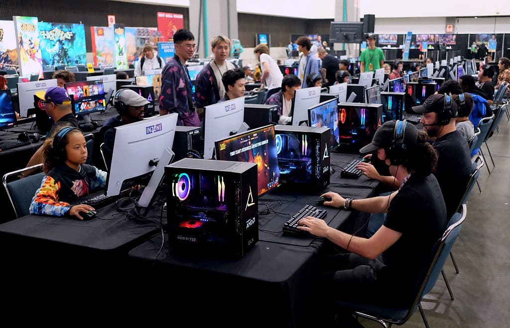 Gente inmersa en videojuegos en LA Comic Con 2025: desde consolas modernas con títulos como Fortnite hasta estaciones VR con experiencias inmersivas.