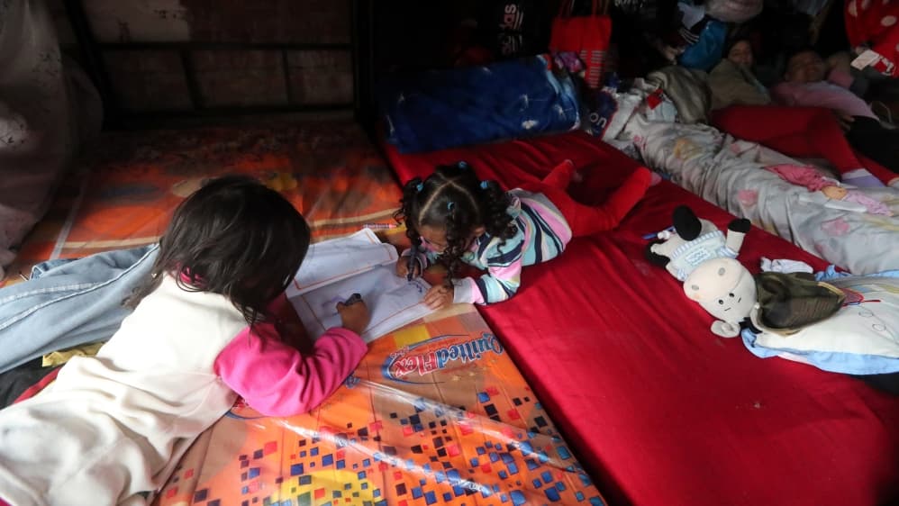 Niños venezolanos con un libro de dibujo en un refugio en Lima, Perú.