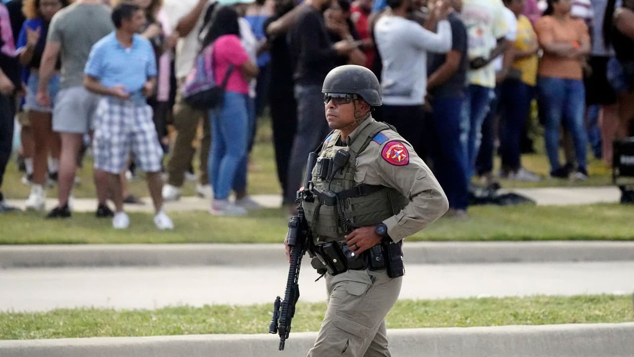 Un agente camina mientras la gente es evacuada en Allen Premium Outlets, donde se produjo un tiroteo masivo, el sábado 6 de mayo de 2023, en Allen, Texas.