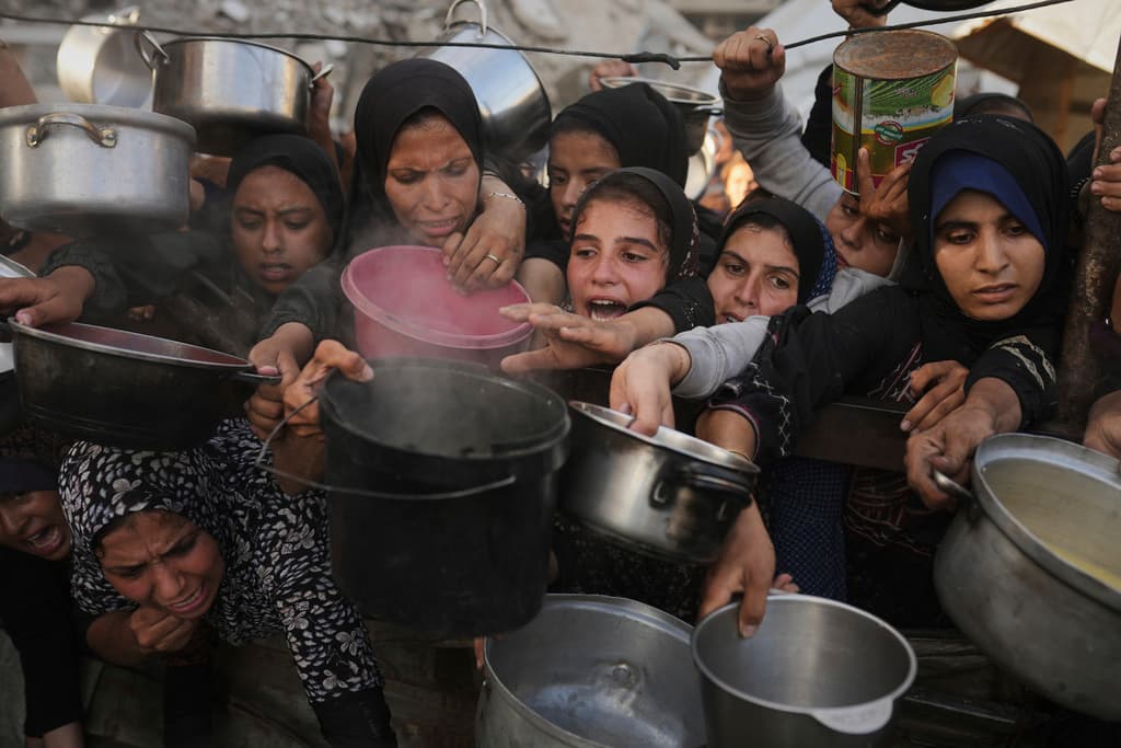 Palestinos luchan por conseguir alimentos donados en un comedor comunitario de la ciudad de Gaza, en el norte de la Franja de Gaza, el lunes 14 de julio de 2025.