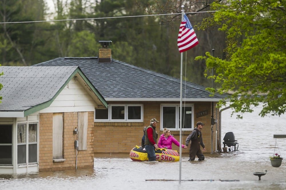 La gente se ayuda mutuamente a desplazarse de un hogar a otro usando una balsa inflable en Oakridge Road, en Beaverton, Michigan. Las evacuaciones incluyen las ciudades de Edenville, Sanford y partes de la ciudad de Midland, que tiene 42,000 personas, según Selina Tisdale, portavoz del condado de Midland.
<br>