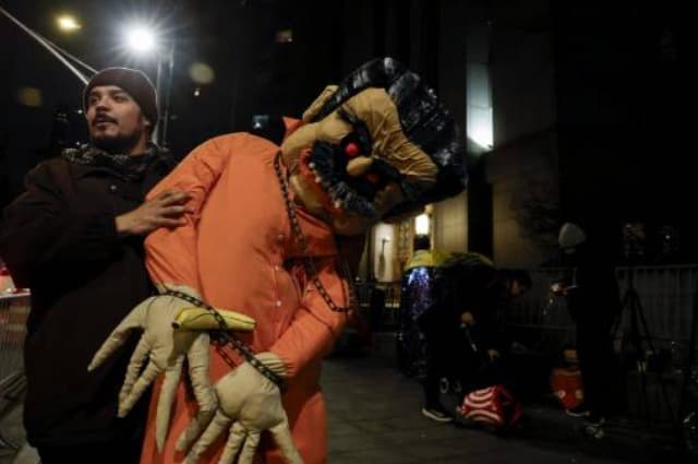 Jorge Torrealba cargando la estatua que elaboró de Maduro vestido de prisionero, la cual entregó a la comunidad venezolana afuera de la Corte para que se "desestresaran".