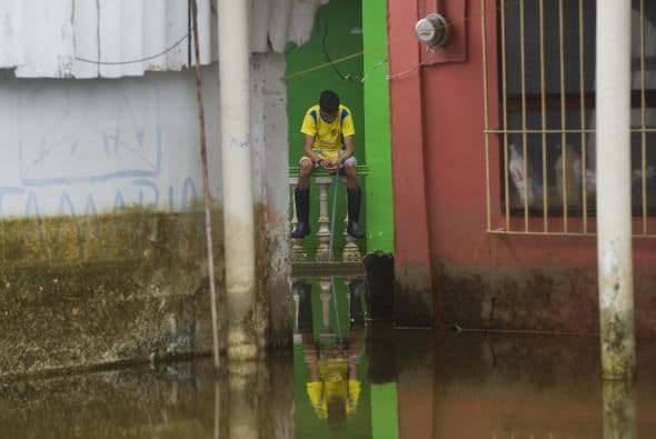 En una esquina, un viejo letrero semisumergido aún deja leer con letras grandes: "Nunca me iré de mi pueblo". No lejos el pequeño puente García, construido en 1857, según reza una placa, ha soportado estoicamente las corrientes. Al cruzarlo es difícil creer con toda el agua que lo rodea, que Tlacotalpan fue alguna vez un pueblo sobre tierra firme.