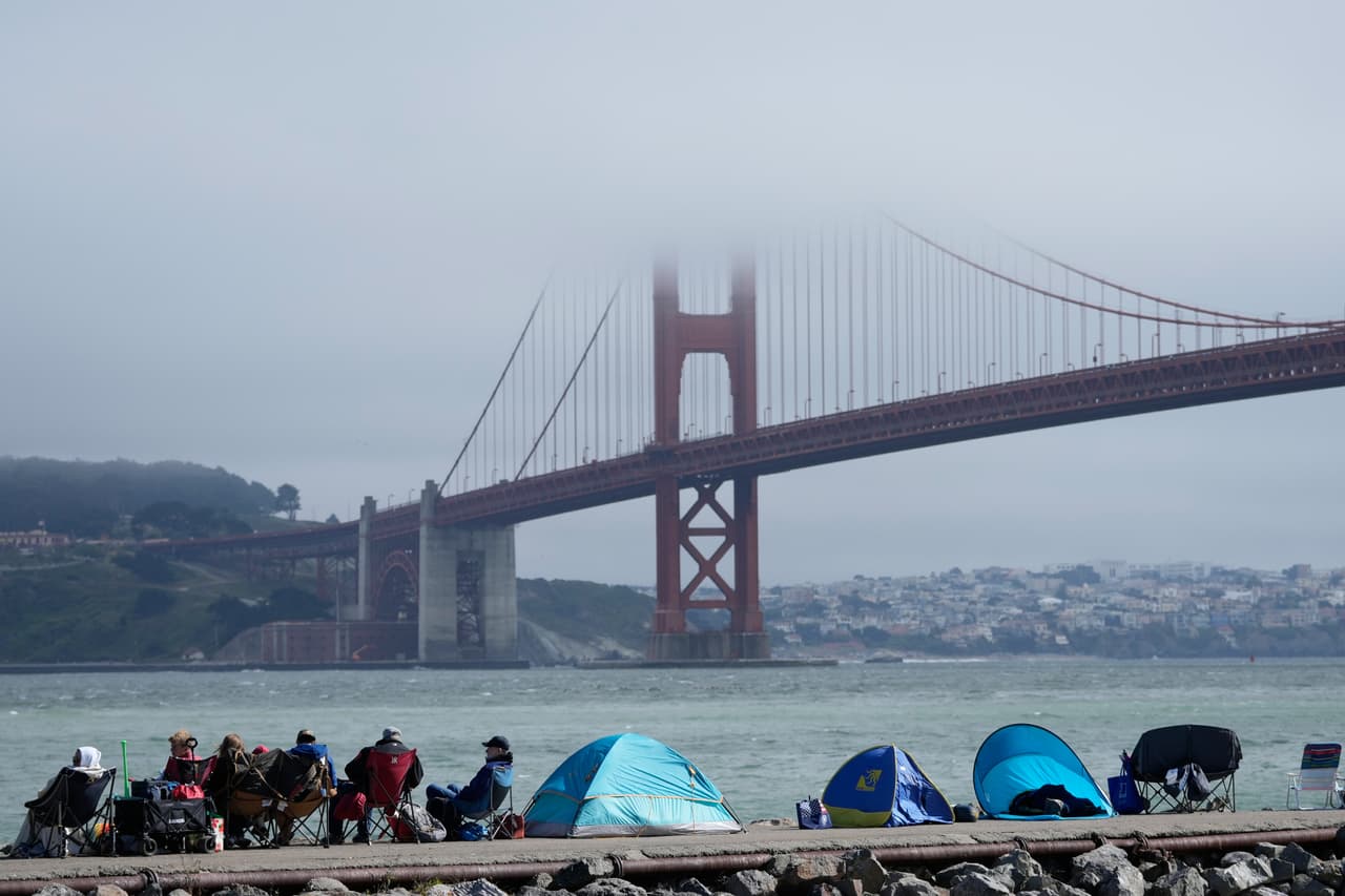 La niebla cubre parcialmente el puente Golden Gate mientras la gente espera a lo largo de la orilla antes del espectáculo de fuegos artificiales programado, el sábado 4 de julio de 2026, en Sausalito, California.