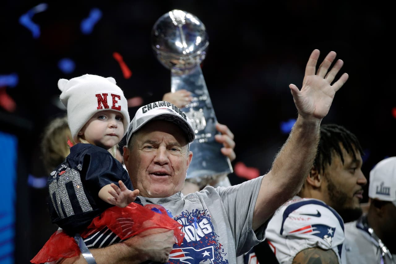 Belichick ya ataviado con la camiseta que se reparte a los campeones del Super Bowl, y también con su gorra en el templete de los monarcas.