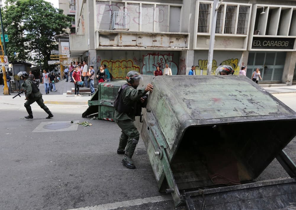 Efectivos de la Guardia Nacional retiran contenedores de basura que los manifestantes volcaron en las calles durante las fuertes protestas.