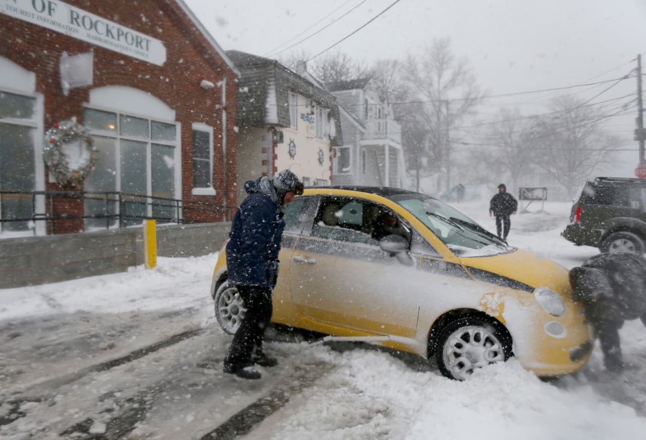 Un meteorólogo The Weather Channel ayuda a un policía de Rockport, Nueva Jersey, a liberar un auto atascado en la nieve.