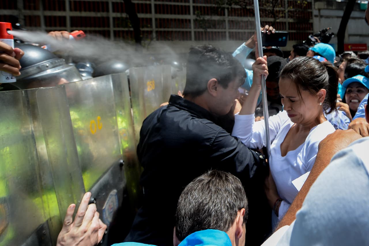 María Corina Machado, líder opositora venezolana y exdiputada, es atacada con gas pimienta por funcionarios de la Policía Nacional en otra protesta en Caracas el 4 de abril de 2017.