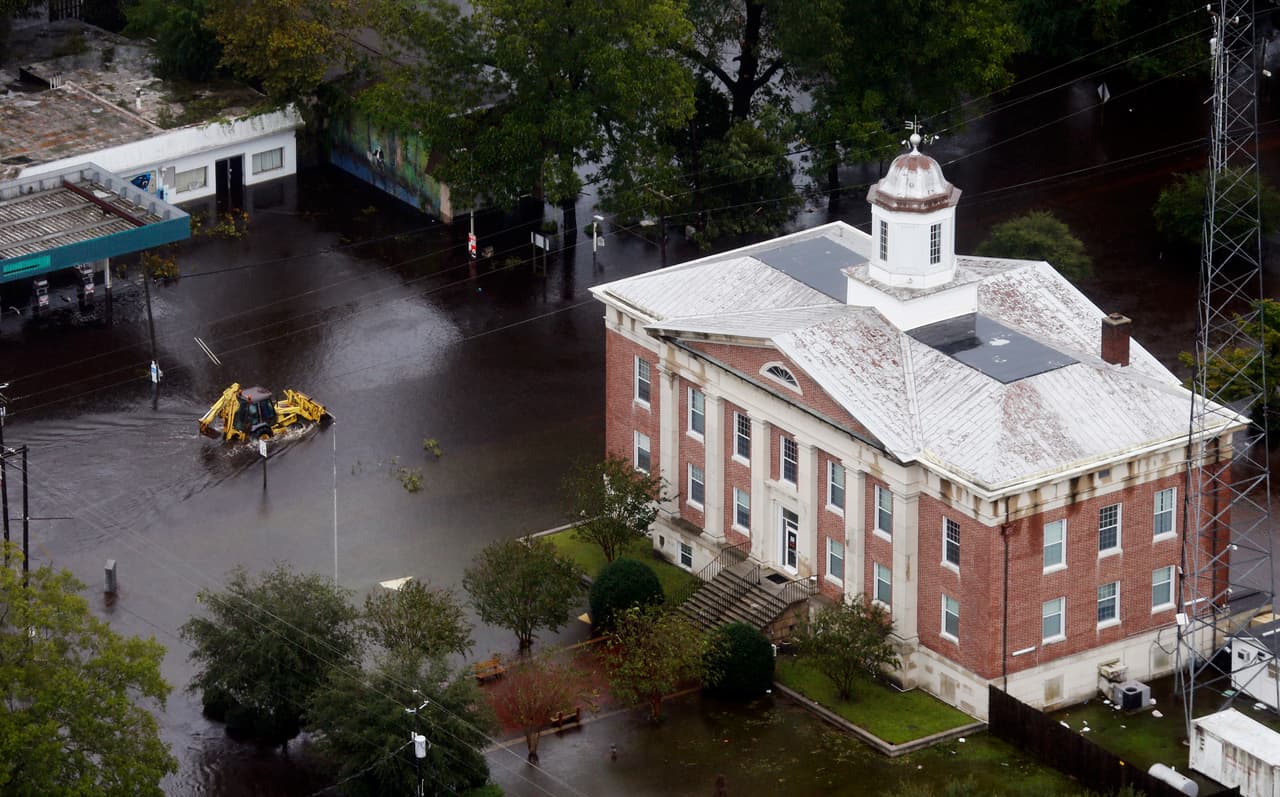 Una retroexcavadora se desplaza por las calles inundadas de Trenton, en Carolina del Norte, golpeada por Florence.