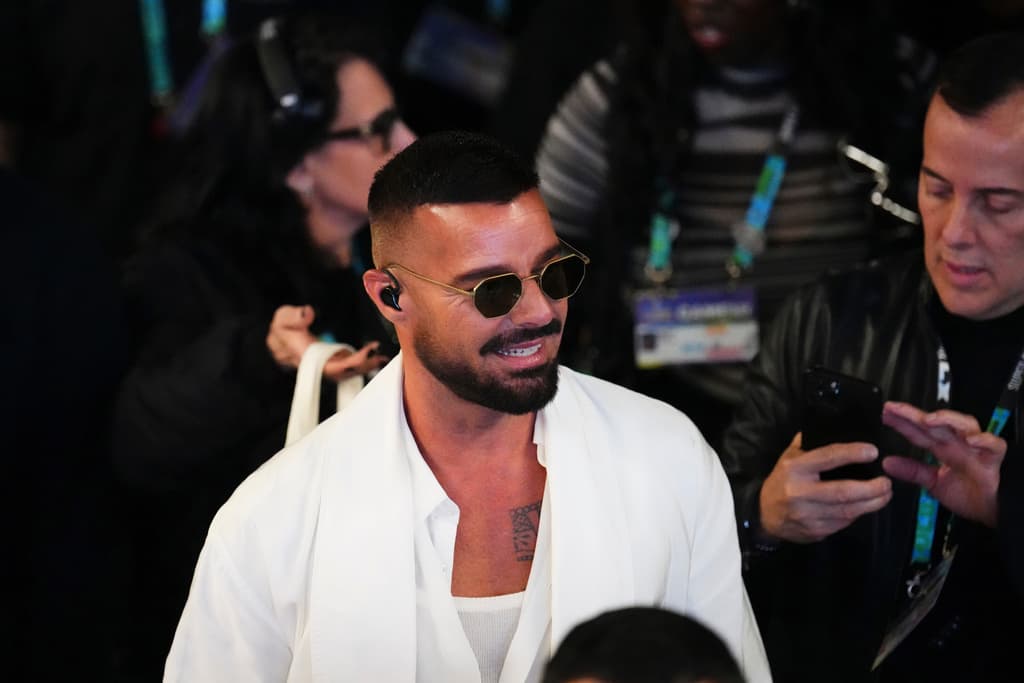 <b>Bad Bunny tenía 4 años</b> cuando 
<b>Ricky Martin</b> (de blanco) hizo historia al interpretar 'La Copa de la Vida' en
<b> <a href="https://www.univision.com/los-angeles/klve/musica/el-sabor-latino-en-las-canciones-de-los-mundiales-de-futbol-fotos" target="_blank">la Copa Mundial de la FIFA, en el 1998, en Francia</a>. </b>
<br>
<b>A 28 años de ese evento</b> que transformó su carrera, el domingo fue el invitado sorpresa del show del medio tiempo que ofreció el 'Conejo' en Santa Clara, California.
<br>Ricky Martin llegó con 
<b>su asistente y quien fuera su coreógrafo <a href="https://www.univision.com/shows/despierta-america/el-precio-de-la-fama-johnny-lozada-habla-tras-el-estreno-del-documental-de-menudo-en-nueva-york-video" target="_blank">en el grupo Menudo</a>, Joselo Vega (a su derecha)</b>.