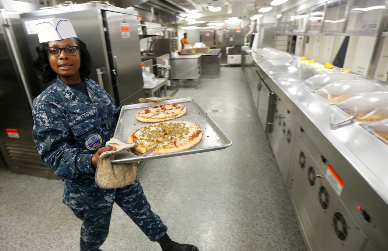Debajo de la cubierta de la nave hay un laberinto de escotillas de acero y pasillos que descienden 11 niveles. Hay servicio médico, barberías, gimnasios y estación de bomberos, entre otras instalaciones. La cocina sirve más de 15,000 platos diarios para la tripulación.