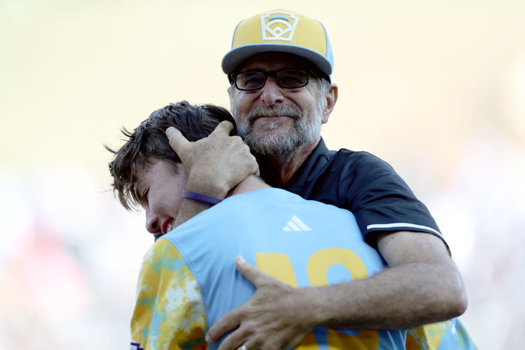 El dirigente de El Segundo, Danny Boehle, abraza al jugador estrella Louis Lappe tras expresarse convencido de que "lo que hicimos, tal vez nunca vuelva a suceder en la historia" de este equipo de béisbol de las Pequeñas Ligas.