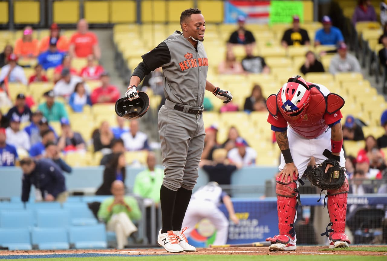 Xander Boagerts reacciona con dolor tras ser golpeado por un lanzamiento. Yadier Molina presente en la imagen.