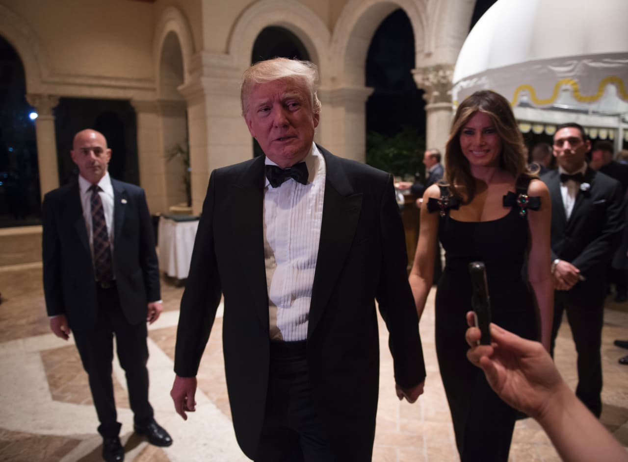El presidente electo, Donald Trump, se dirige a los reporteros acompañado por su esposa Melania en su fiesta de fin de año en Mar-a-Lago en Palm Beach, Florida.