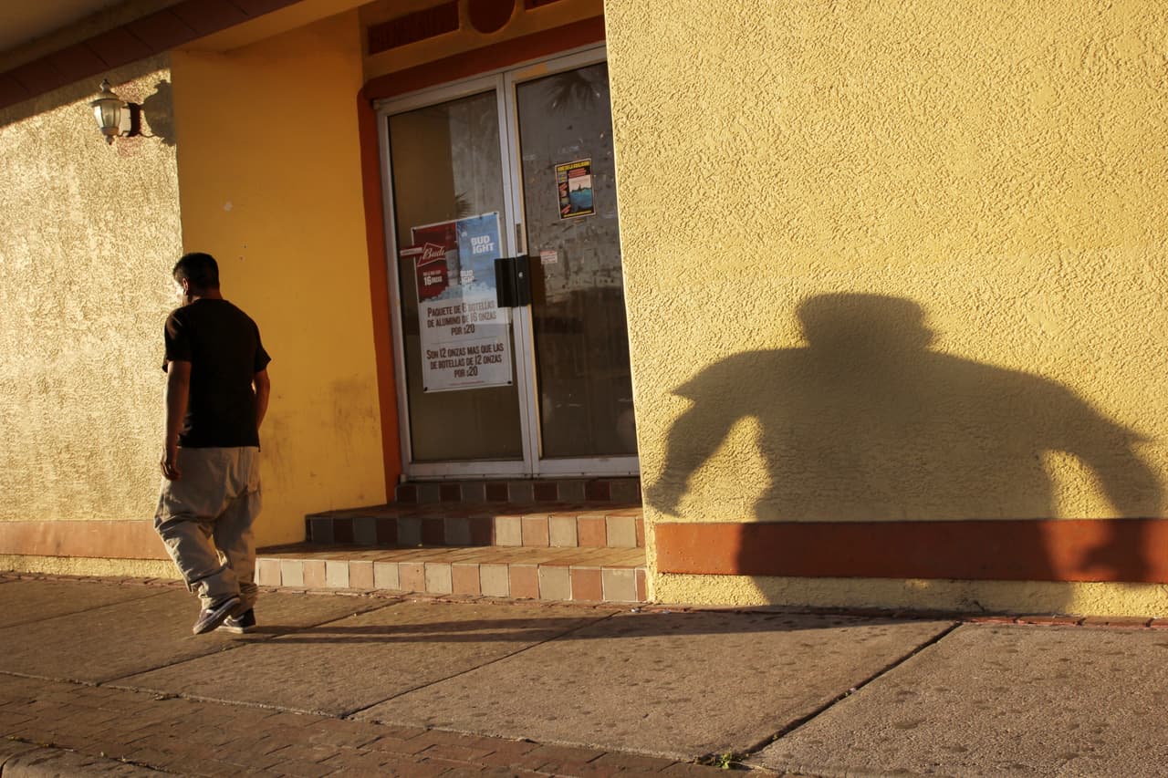 Un inmigrante camina en el Main Street de Immokalee, Florida, al atardecer.