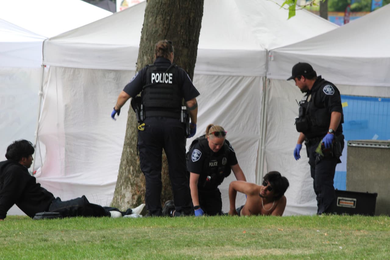 Police attend to a person after a shooting at Seattle Center during the Bite of Seattle food festival Sunday, July 26, 2026, in Seattle, Wash. (Estan Wakonabo via AP)