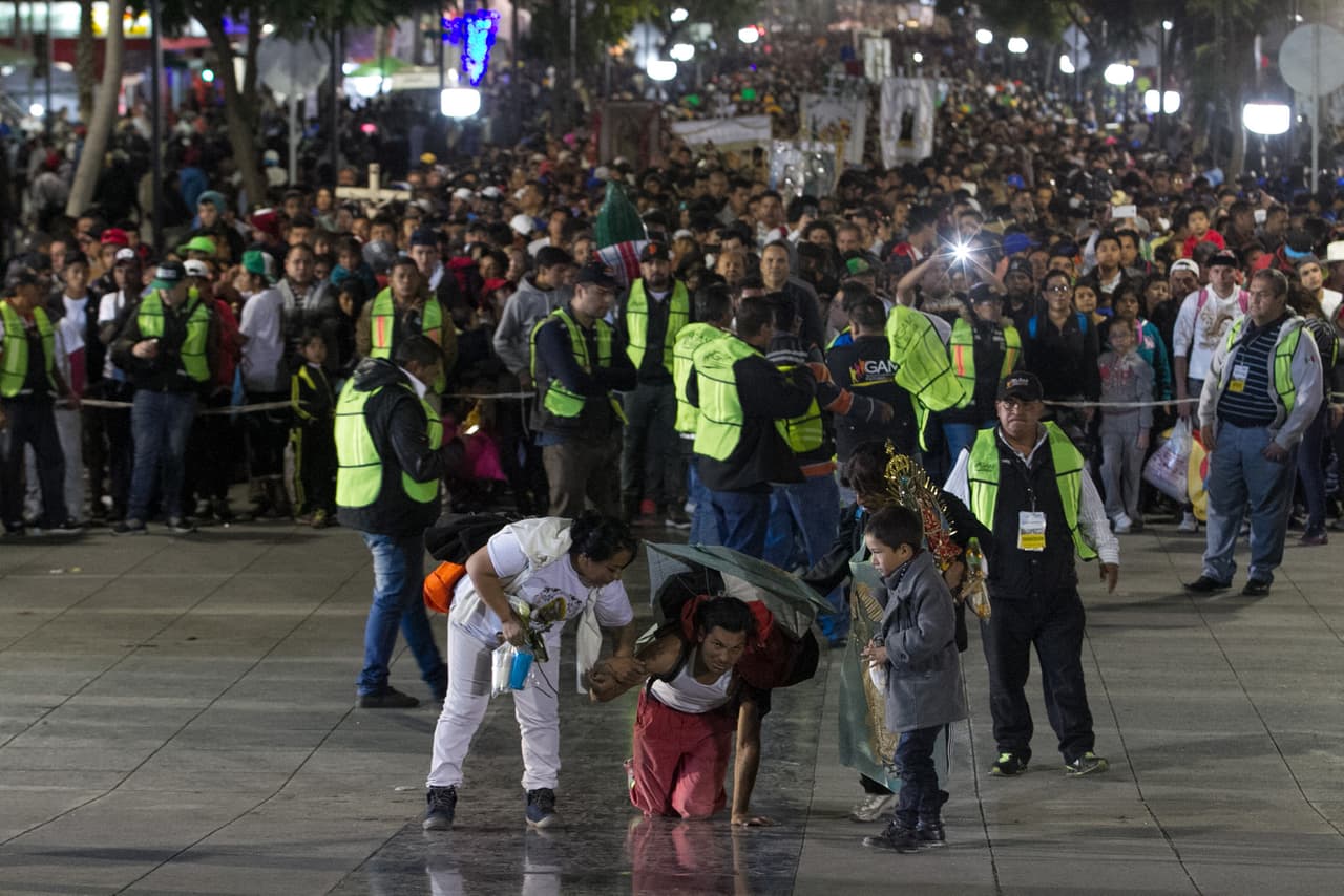 Un hombre camina de rodillas rumbo a la entreda de la Basílica.