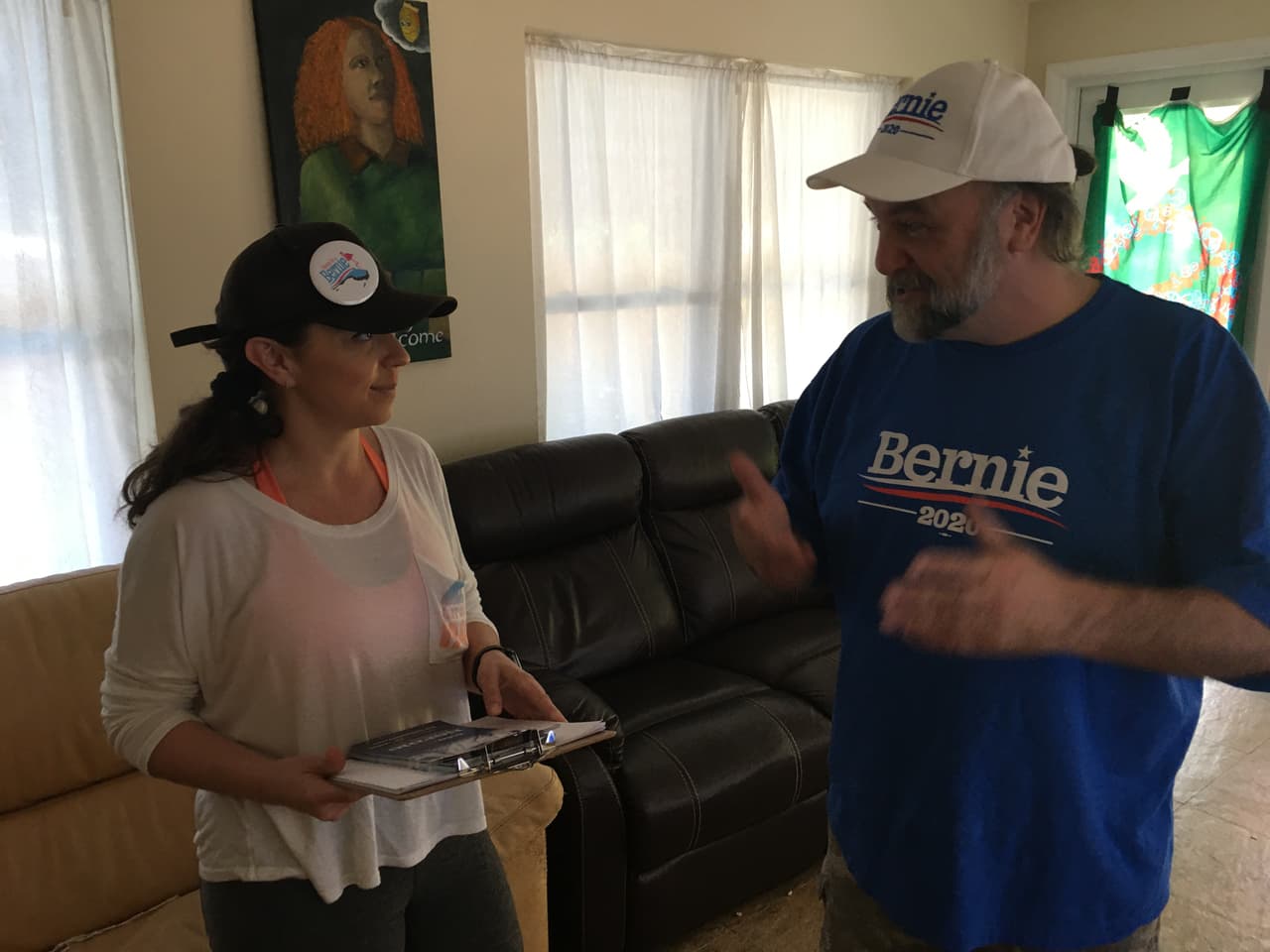 AJ Nichols con la voluntaria Ciera Duque, de 32 años de edad, asistente administrativa en la industria hospitalaria y originaria de Colombia, recibe instrucciones para ayudar a la campaña de Bernie Sanders.