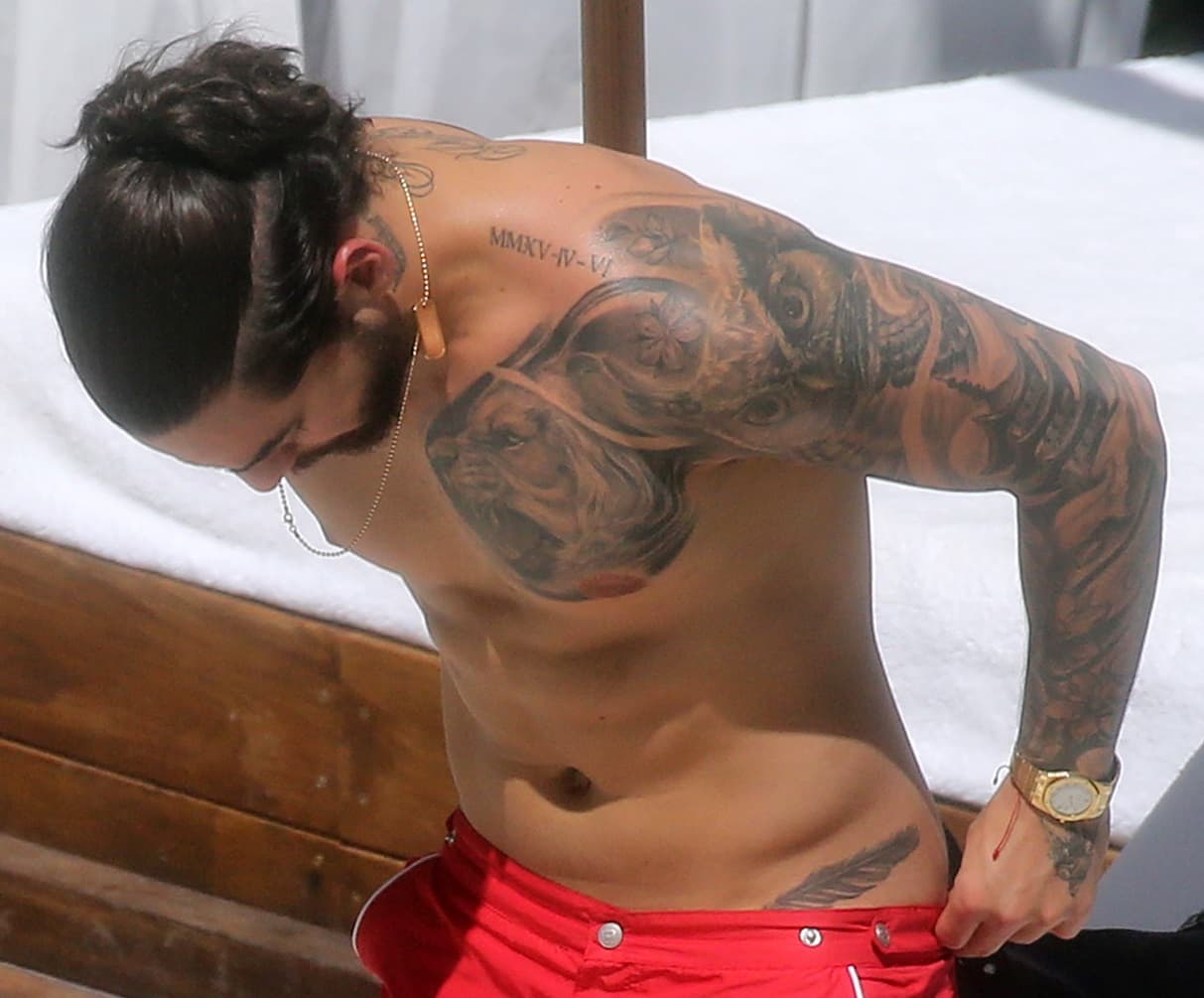 Los números romanos en los hombros de Maluma son las fechas de nacimiento de sus primos consentidos. ¿Es una pluma lo que adorna su cadera? Pareciera que sí.