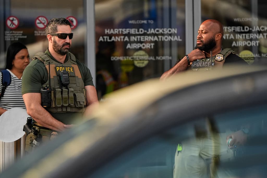 Esta foto también muestra a 
<b>agentes federales parados en el exterior del aeropuerto de Atlanta. </b>
<br>
<br>Se cree que ayudarán también en la verificación inicial de identificaciones y el manejo de filas.